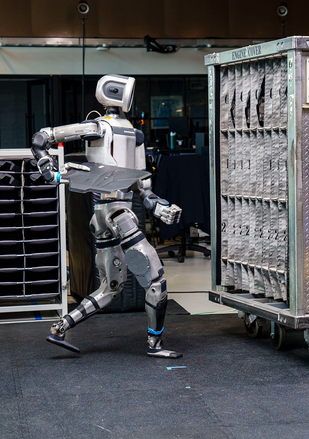 Atlas walks to place an engine cover in a sequencing dolly