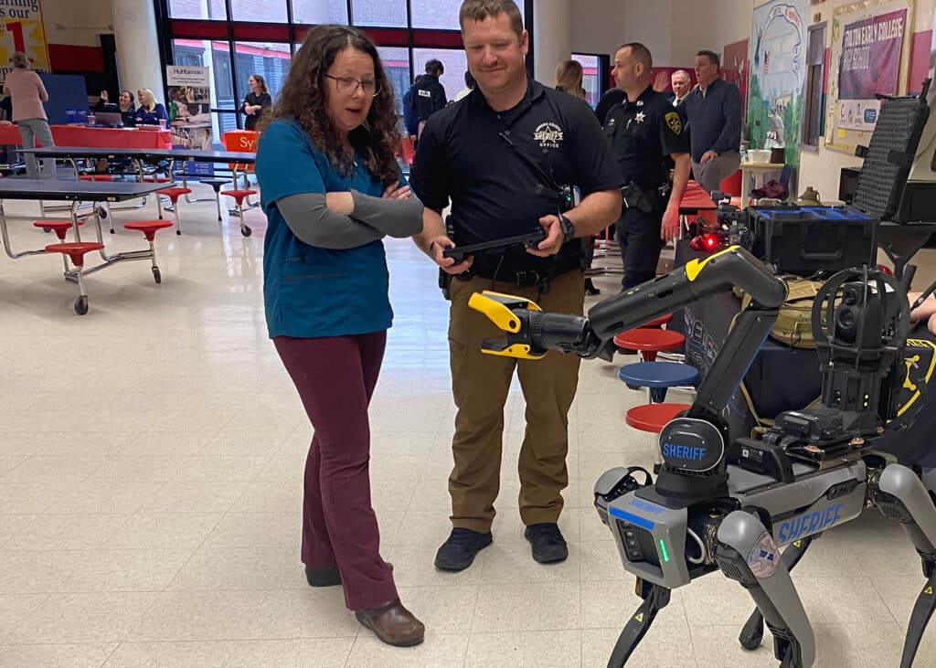 An operator from the Oswego County Sheriff's Department demos the Spot robot in a school setting