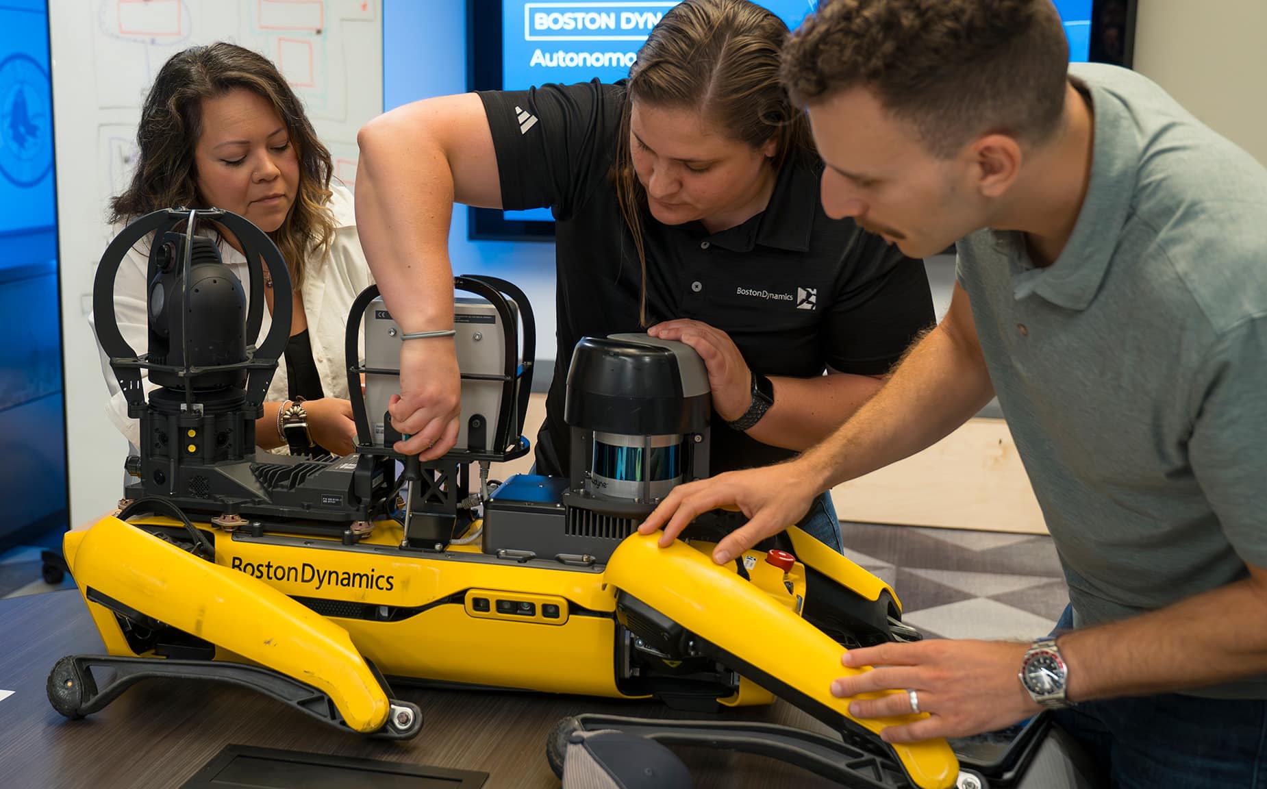 A trainer demonstrates mounting a payload on Spot